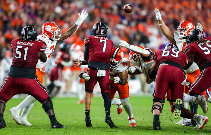 Nov 25, 2023; Columbia, South Carolina, USA; South Carolina Gamecocks quarterback Spencer Rattler (7) throws a pass as he is hit by Clemson Tigers linebacker Jeremiah Trotter Jr. (54) in the second half at Williams-Brice Stadium. Mandatory Credit: Jeff Blake-USA TODAY Sports  